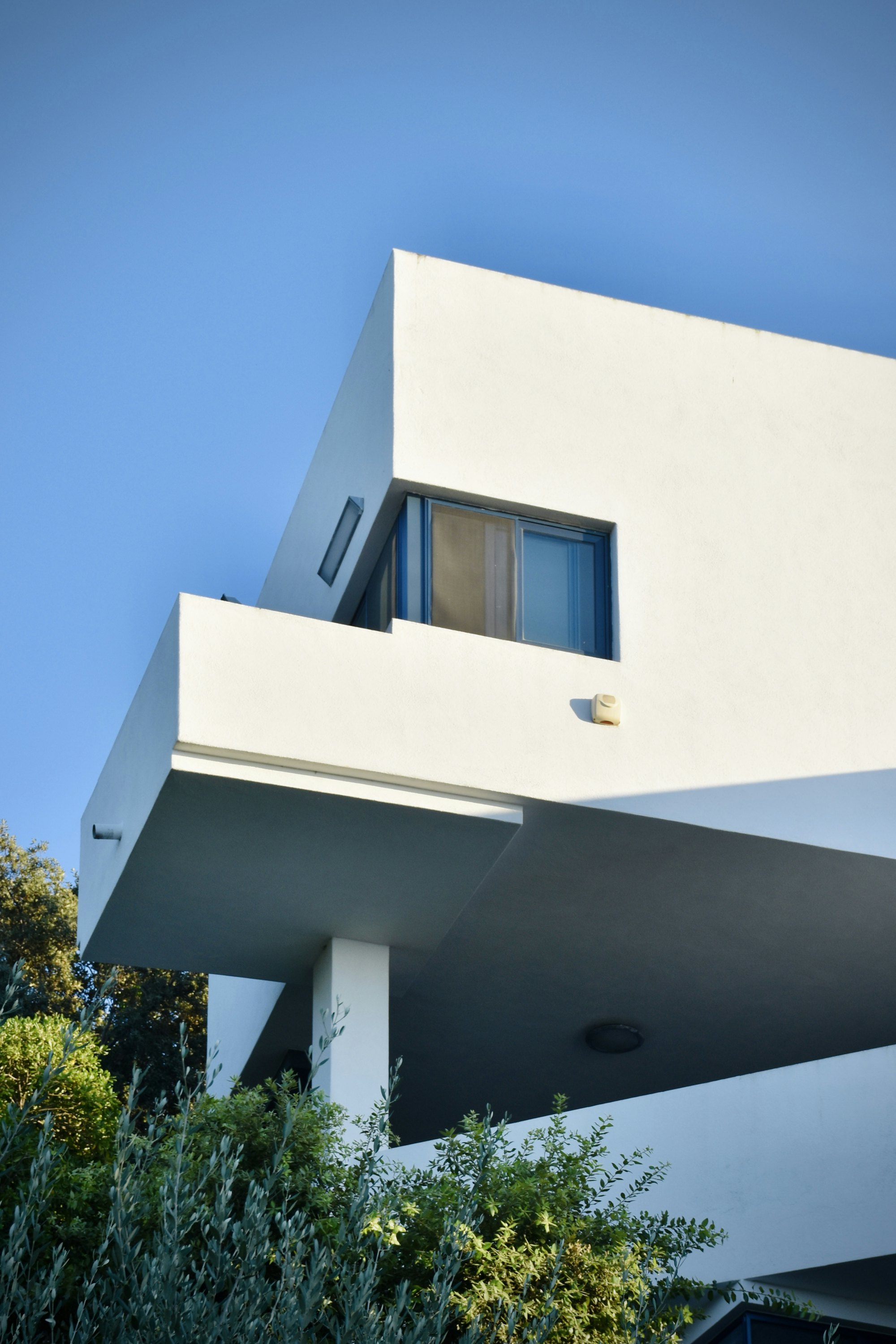 Detalle de fachada blanca con ventana, imagen referencial
